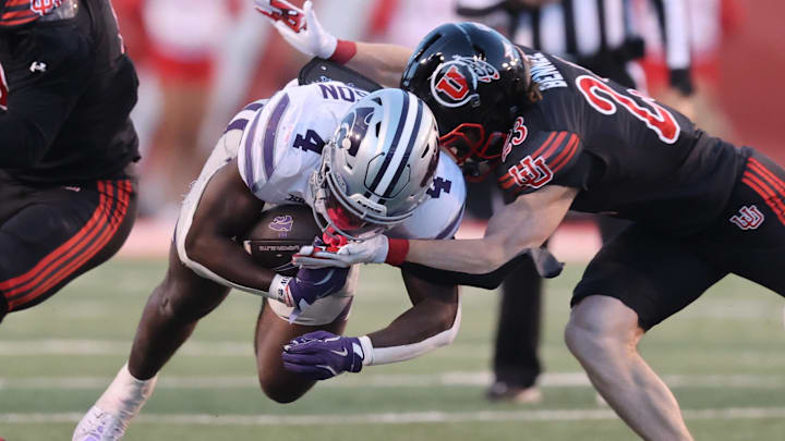 Nov 22, 2025; Salt Lake City, Utah, USA; Kansas State Wildcats running back Joe Jackson (4) is tackled by Utah Utes safety Jackson Bennee (23) during the second half at Rice-Eccles Stadium. 