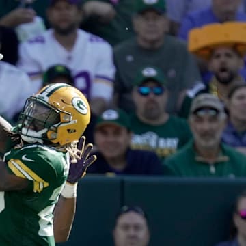 Green Bay Packers safety Xavier McKinney (29) leaps for an interception in front of the Vikings' Aaron Jones.