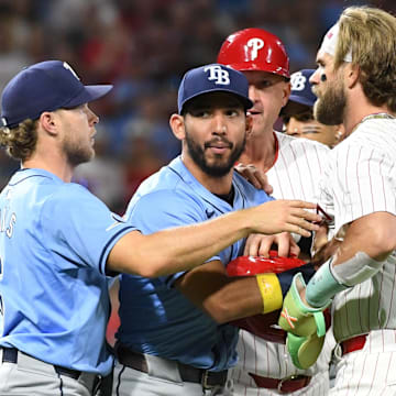 Sep 10, 2024; Philadelphia, Pennsylvania, USA; Philadelphia Phillies first baseman Bryce Harper is held back by Tampa Bay Rays shortstop José Caballero.