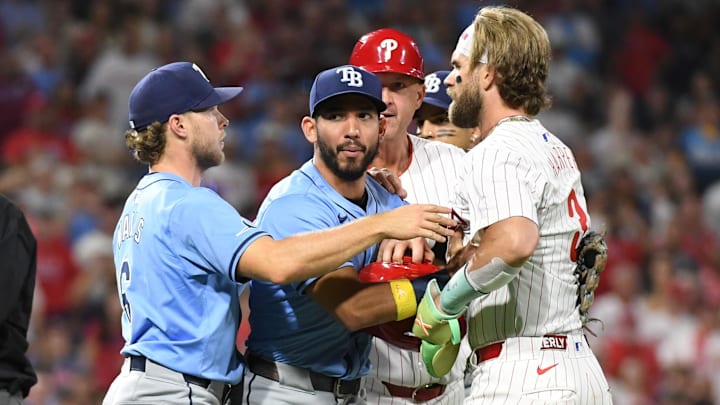 Sep 10, 2024; Philadelphia, Pennsylvania, USA; Philadelphia Phillies first baseman Bryce Harper is held back by Tampa Bay Rays shortstop José Caballero.