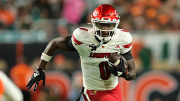 Oct 17, 2025; Miami Gardens, Florida, USA; Louisville Cardinals wide receiver Chris Bell (0) carries the football against the Miami Hurricanes during the first quarter at Hard Rock Stadium. Mandatory Credit: Sam Navarro-Imagn Images