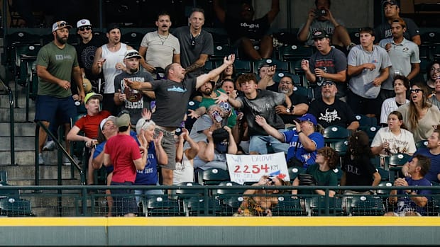Fans at Coors Field in Colorado attempto to catch a ball. 