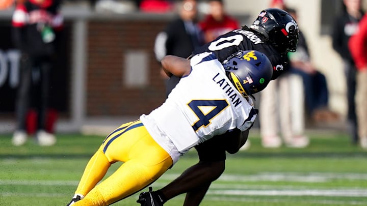 West Virginia Mountaineers linebacker Trey Lathan (4) tackles Cincinnati Bearcats wide receiver Tony Johnson (0) in the fourth quarter of a college football game between the Cincinnati Bearcats and West Virginia Mountaineers, Saturday, Nov. 9, 2024, at Nippert Stadium in Cincinnati. Mountaineers won 31-24.