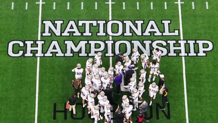 The Huskies huddle on the field during the second quarter of the CFP national championship game against Michigan.