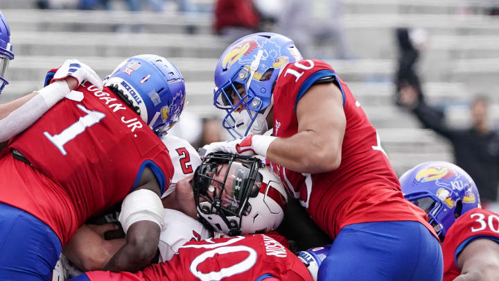 Nov 11, 2023; Lawrence, Kansas, USA; Texas Tech Red Raiders quarterback Behren Morton (2) runs the ball and nearly loses his helmet as Kansas Jayhawks linebacker Jayson Gilliom (10) makes the tackle during the first half at David Booth Kansas Memorial Stadium. 