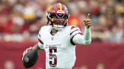 Sep 29, 2024; Glendale, Arizona, USA; Washington Commanders quarterback Jayden Daniels (5) runs the ball against the Arizona Cardinals in the first half at State Farm Stadium. Mandatory Credit: Mark J. Rebilas-Imagn Images