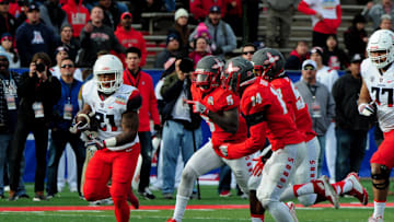 Dec 19, 2015; Albuquerque, NM, USA; Arizona Wildcats running back Orlando Bradford (21) carries the ball as New Mexico Lobos safety Lee Crosby (5) and safety Daniel Henry (14) defend during the second half in the 2015 New Mexico Bowl at University Stadium. Mandatory Credit: Matt Kartozian-USA TODAY Sports