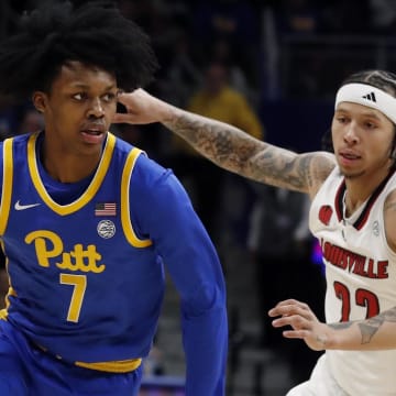 Feb 17, 2024; Pittsburgh, Pennsylvania, USA;  Pittsburgh Panthers guard Carlton Carrington (7) drives to the basket against Louisville Cardinals guard Tre White (22) during the first half at the Petersen Events Center. Mandatory Credit: Charles LeClaire-USA TODAY Sports