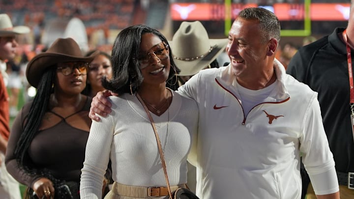 Texas Longhorns head coach Steve Sarkisian and his wife Loreal Sarkisian walk off the field after defeating the Kentucky Wildcats.