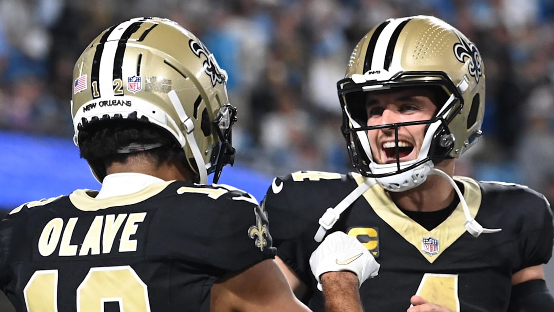Sep 18, 2023; Charlotte, North Carolina, USA; New Orleans Saints quarterback Derek Carr (4) reacts with wide receiver Chris Olave (12) in the fourth quarter at Bank of America Stadium. 