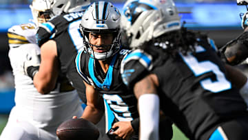 Nov 9, 2025; Charlotte, North Carolina, USA; Carolina Panthers quarterback Bryce Young (9) fakes a handoff to running back Rico Dowdle (5) in the third quarter at Bank of America Stadium.