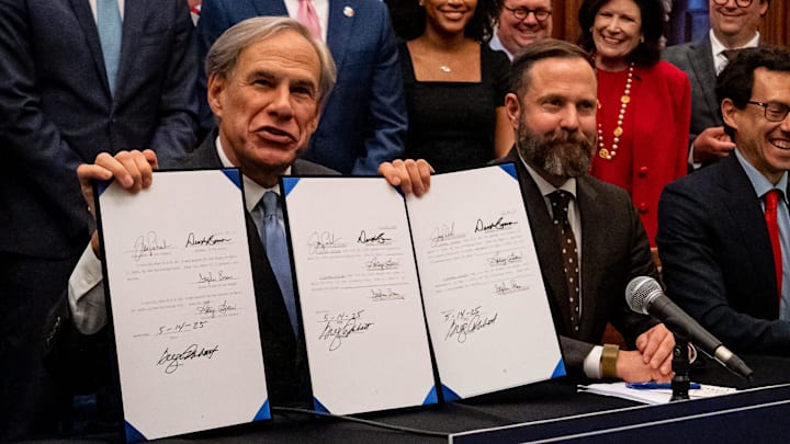Texas Governor Greg Abbott, left, signs a series of business-friendly bills at the Texas State Capitol, May 14, 2025.