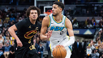 Apr 10, 2025; Indianapolis, Indiana, USA; Indiana Pacers guard Tyrese Haliburton (0) dribbles the ball while Cleveland Cavaliers guard Craig Porter Jr. (9) defends in the second half at Gainbridge Fieldhouse. Mandatory Credit: Trevor Ruszkowski-Imagn Images