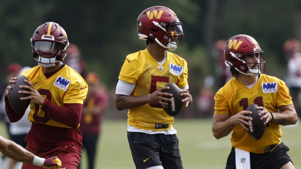  Washington Commanders quarterbacks Marcus Mariota (0), Jayden Daniels (5), and Sam Hartman (11) drop back to pass a ball