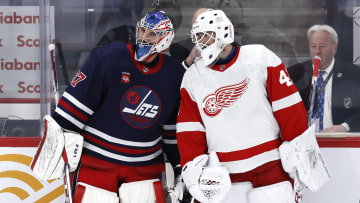 Winnipeg Jets goaltender Connor Hellebuyck (37) and Detroit Red Wings netminder James Reimer (47) talk during warm-ups.