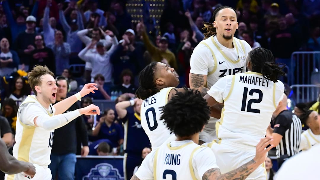 Mar 14, 2026; Cleveland, OH, USA; Akron Zips players celebrate with guard Shammah Scott, top right, after Scott hit a three point basket to win the game against the Toledo Rockets in the men’s Mid-American Conference Championship at Rocket Arena. Mandatory Credit: Ken Blaze-Imagn Images