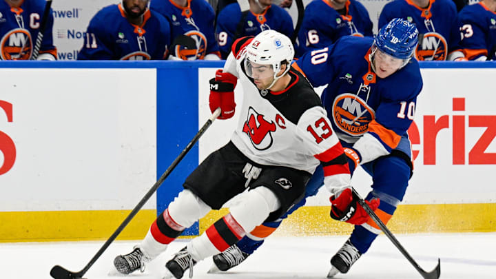 New York Islanders right wing Simon Holmstrom (10) defends against New Jersey Devils center Nico Hischier (13): Dennis Schneidler-Imagn Images