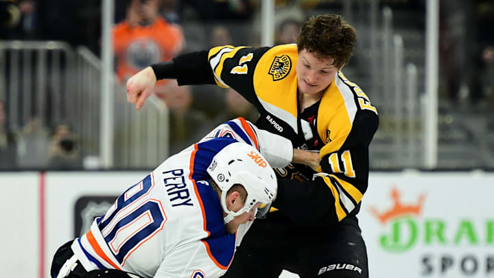 Jan 7, 2025; Boston, Massachusetts, USA;  Boston Bruins center Trent Frederic (11) fights with Edmonton Oilers right wing Corey Perry (90) during the second period at TD Garden. Mandatory Credit: Bob DeChiara-Imagn Images