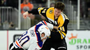 Jan 7, 2025; Boston, Massachusetts, USA;  Boston Bruins center Trent Frederic (11) fights with Edmonton Oilers right wing Corey Perry (90) during the second period at TD Garden. Mandatory Credit: Bob DeChiara-Imagn Images