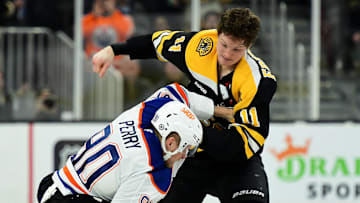 Jan 7, 2025; Boston, Massachusetts, USA;  Boston Bruins center Trent Frederic (11) fights with Edmonton Oilers right wing Corey Perry (90) during the second period at TD Garden. Mandatory Credit: Bob DeChiara-Imagn Images