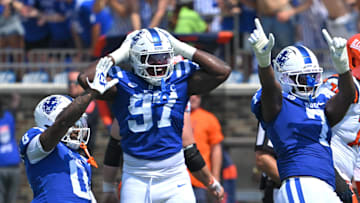 Sep 6, 2025; Durham, North Carolina, USA;  Duke Blue Devils cornerback Chandler Rivers (0), linebacker Jaiden Francois (2) and cornerback Kimari Robinson (5) celebrate a tackle by defensive end Vincent Anthony Jr.'s (7) against the Illinois Fighting Illini during the first quarter at Wallace Wade Stadium. Mandatory Credit: Zachary Taft-Imagn Images
