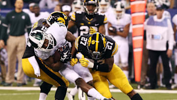 Dec 5, 2015; Indianapolis, IN, USA; Michigan State Spartans wide receiver Aaron Burbridge (16) is tackled by Iowa Hawkeyes defensive back Jordan Lomax (27), and wide receiver Joshua Jackson (15) during the third quarter in the Big Ten Conference football championship game at Lucas Oil Stadium. Mandatory Credit: Aaron Doster-Imagn Images