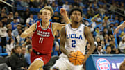 Nov 3, 2025; Los Angeles, California, USA;  UCLA Bruins guard Donovan Dent (2) drives to the basket between Eastern Washington Eagles guard Cole Scherer (11) and guard Alton Hamilton IV (4) during the second half at Pauley Pavilion presented by Wescom Financial. Mandatory Credit: Kiyoshi Mio-Imagn Images