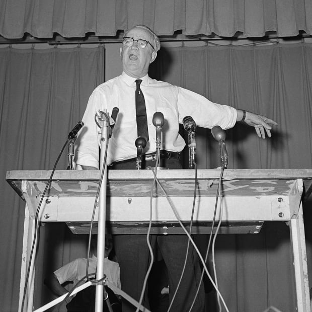 Bull Connor stands in front of microphones. 