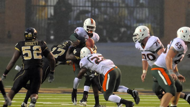 October 31, 2009; Winston-Salem, NC, USA; Miami Hurricanes quarterback Jacory Harris (12) loses the ball after being hit by Wake Forest Demon Deacons cornerback Brandon Ghee (17) in the second half at BB&T Field. Miami defeated Wake Forest 28-27. Mandatory Credit: Dale Zanine-Imagn Images