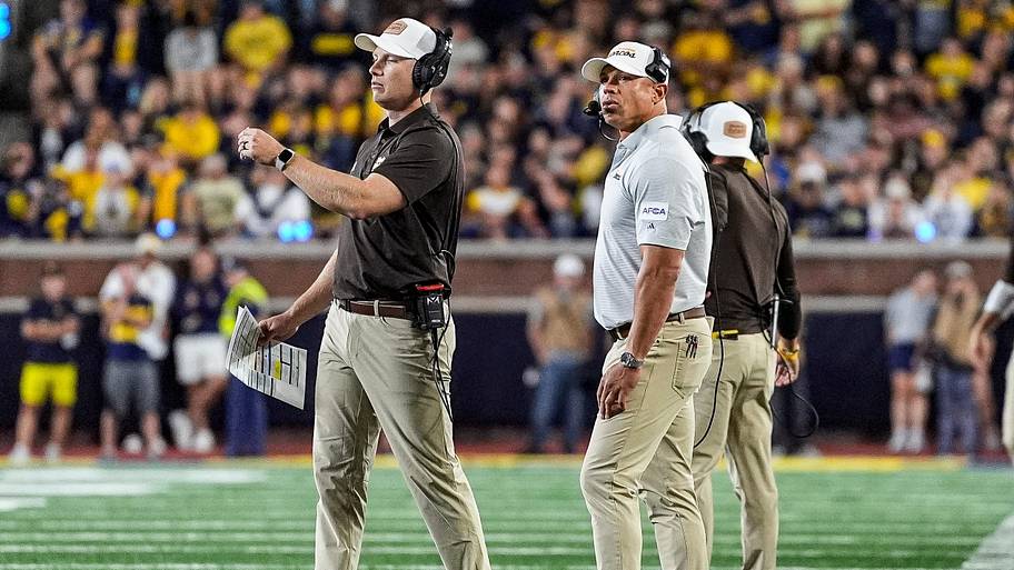 Western Michigan head coach Lance Taylor, center, watches a replay against Michigan.
