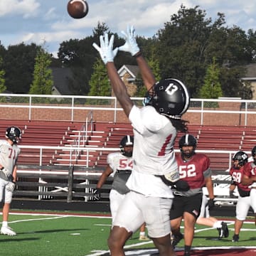 Ballard High School receiver Malachi Allen leaps for a ball Tuesday, Oct. 21, at a Bruin practice. Ballard just might have the most challenging regular-season schedule in the state.