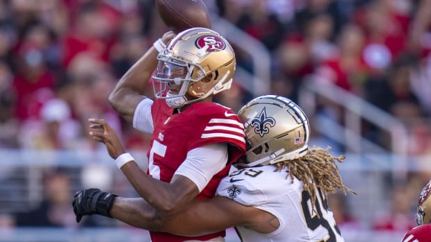 San Francisco 49ers quarterback Joshua Dobbs (5) passes as he's hit by New Orleans Saints defensive end Chase Young (99) 