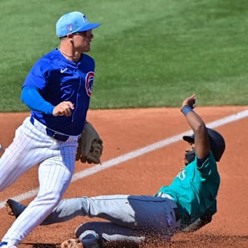 Mar 8, 2024; Mesa, Arizona, USA;  Seattle Mariners shortstop Ryan Bliss (1) slides into third base as Chicago Cubs third baseman Matt Shaw (77) defends in the second inning during a spring training game at Sloan Park. 