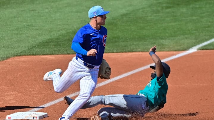 Mar 8, 2024; Mesa, Arizona, USA;  Seattle Mariners shortstop Ryan Bliss (1) slides into third base as Chicago Cubs third baseman Matt Shaw (77) defends in the second inning during a spring training game at Sloan Park. 