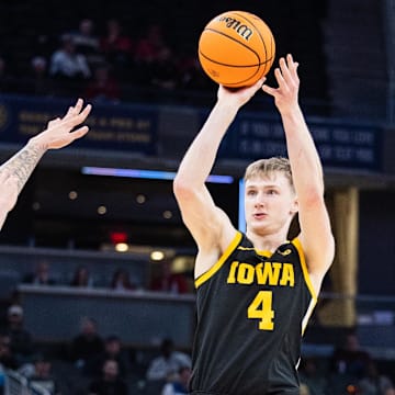 Mar 12, 2025; Indianapolis, IN, USA; Iowa Hawkeyes guard Josh Dix (4) shoots the ball while Ohio State Buckeyes guard John Mobley Jr. (0) defends in the first half  at Gainbridge Fieldhouse. Mandatory Credit: Trevor Ruszkowski-Imagn Images