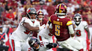 Sep 8, 2024; Tampa, Florida, USA;  Washington Commanders quarterback Jayden Daniels (5) runs the ball for a touchdown against the Tampa Bay Buccaneers in the fourth quarter at Raymond James Stadium. Mandatory Credit: Nathan Ray Seebeck-Imagn Images