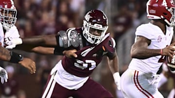Alabama Crimson Tide quarterback Jalen Milroe (4) moves in the pocket while defended by Mississippi State Bulldogs defensive end Deonte Anderson (91) during the second quarter at Davis Wade Stadium at Scott Field.