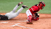 Stetson Hatters' Foster Apple (8) slides safely into home as 
NC State Wolfpack's Alex Sosa (13) catches the late throw during the NCAA Baseball Regional Tournament at Plainsman Park in Auburn, Ala., on Friday May 30, 2025.