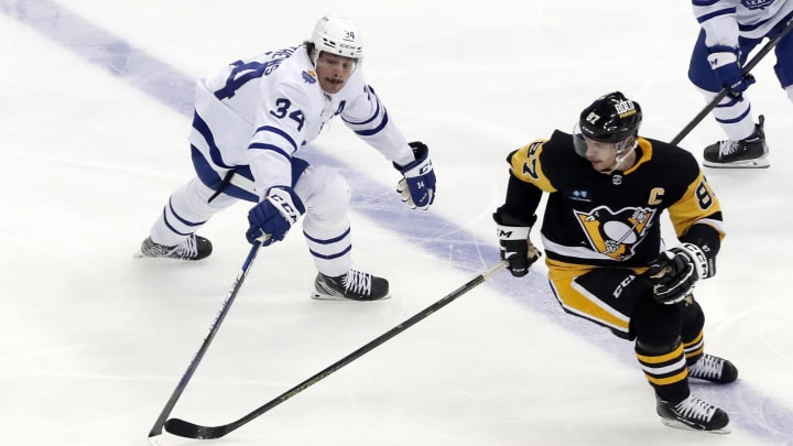 Nov 26, 2022; Pittsburgh, Pennsylvania, USA; Toronto Maple Leafs center Auston Matthews (34) and Pittsburgh Penguins center Sidney Crosby (87) reach for the puck during the third period at PPG Paints Arena. Toronto won 4-1. Mandatory Credit: Charles LeClaire-USA TODAY Sports