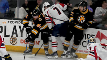 Providence Bruins center Fraser Minten and forward Fabian Lysell fighting for possession against Thundrbird Leo Loofin the second period.