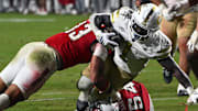 Nov 1, 2025; Raleigh, North Carolina, USA;  North Carolina State Wolfpack linebacker Kenny Soares Jr. (33) tackles Georgia Tech Yellow Jackets running back Jamal Haynes (1) during the fourth quarter at Carter-Finley Stadium. Mandatory Credit: Zachary Taft-Imagn Images