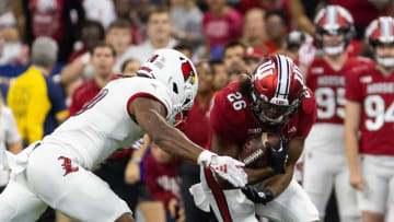 Sep 16, 2023; Indianapolis, Indiana, USA; Indiana Hoosiers running back Josh Henderson (26) runs the ball against Louisville Cardinals defensive lineman Ashton Gillotte (9)  in the second half at Lucas Oil Stadium. Mandatory Credit: Trevor Ruszkowski-USA TODAY Sports