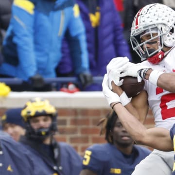 Nov 27, 2021; Ann Arbor, Michigan, USA; Ohio State Buckeyes wide receiver Chris Olave (2) makes a reception over Michigan Wolverines defensive back DJ Turner (5) at Michigan Stadium. Mandatory Credit: Rick Osentoski-USA TODAY Sports