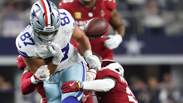 Nov 3, 2025; Arlington, Texas, USA; Dallas Cowboys tight end Jake Ferguson (87) fumbles against Arizona Cardinals linebacker Mack Wilson Sr. (2) and cornerback Garrett Williams (21) in the first half at AT&T Stadium.