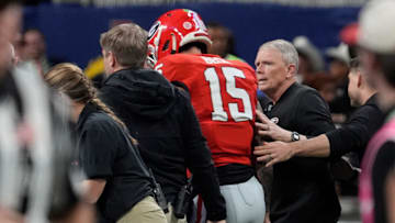 Georgia quarterback Carson Beck (15) is helped off the field after going down after a hit on this trowing shoulder during the first half of the SEC championship game against Texas in Atlanta, on Saturday, Dec. 7, 2024.