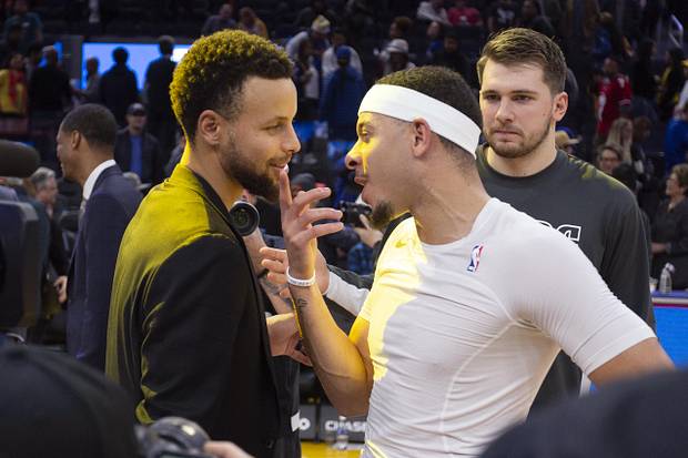 Golden State Warriors guard Stephen Curry, left, exchanges pleasantries with his brother Dallas Mavericks guards Seth Curry