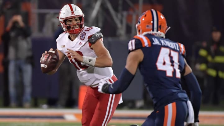 Oct 6, 2023; Champaign, Illinois, USA; Nebraska Cornhuskers quarterback Heinrich Haarberg (10) is pursued by Illinois Fighting Illini linebacker James Kreutz (41) during the first half at Memorial Stadium. Mandatory Credit: Ron Johnson-USA TODAY Sports