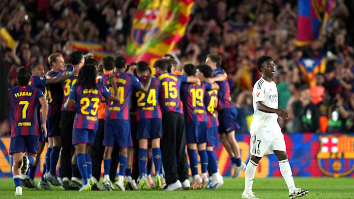 Vinícius Júnior muestra su frustración mientras los jugadores del Barcelona celebran al fondo tras el silbatazo final en el Camp Nou Vinícius Júnior muestra su frustración mientras los jugadores del Barcelona celebran al fondo tras el silbatazo final en el Camp Nou