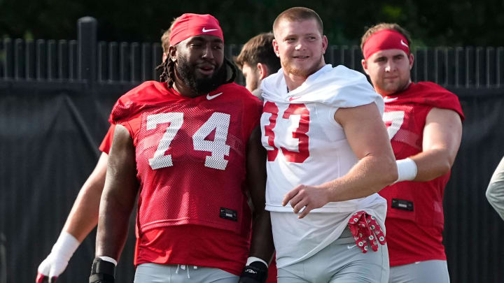 Aug 1, 2024; Columbus, OH, USA; Ohio State Buckeyes offensive lineman Donovan Jackson (74) and defensive end Jack Sawyer (33) stretch during football camp at the Woody Hayes Athletic Complex.