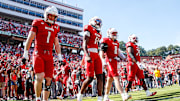 Oct 4, 2025; Raleigh, North Carolina, USA; NC State Wolfpack quarterback CJ Bailey (11), linebacker Caden Fordham (1), wide receiver Keenan Jackson (8) and offensive lineman Jr. Anthony Carter (75) walk out for the coin toss prior to the first half of the game against Campbell Fighting Camels at Carter-Finley Stadium. Mandatory Credit: Jaylynn Nash-Imagn Images